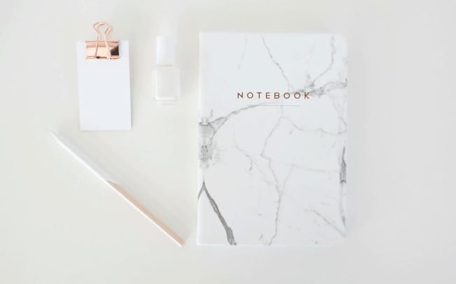 Styled photo of pencil, notebook, notepad and nailpolish