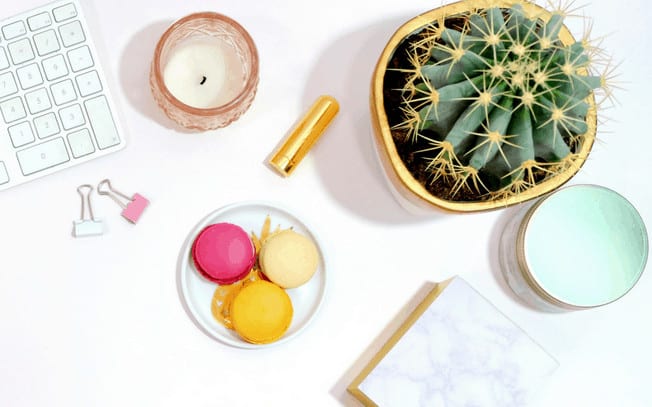 Stylized photo of macrons, cactus, candles and keyboard